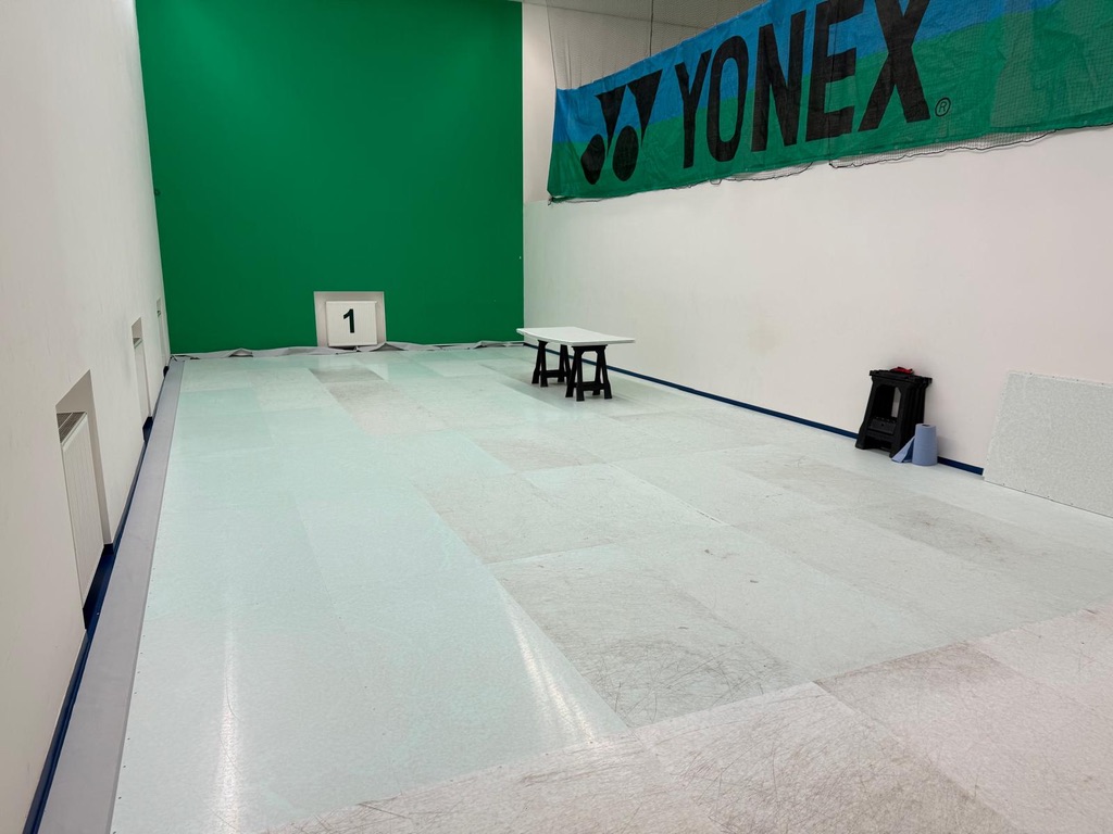 Erste helle Bodenflächen am Green X Arena Pilotstandort Buštěhrad mit Yonex-Banner