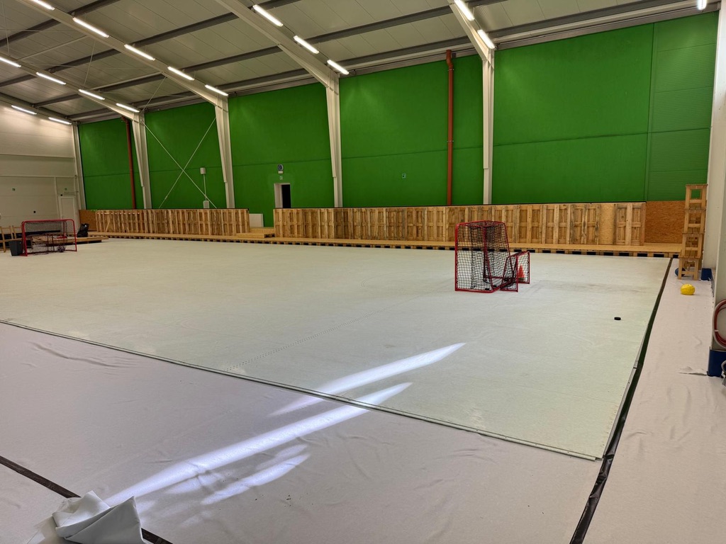 Weite Ansicht der Green-Hockey-Spielfläche mit Toren und entstehender Bande in Buštěhrad